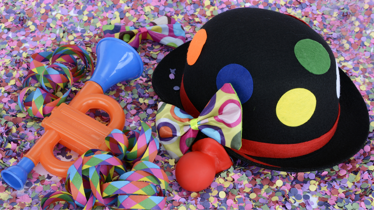 masks and carnival objects of various colours surrounded by confetti